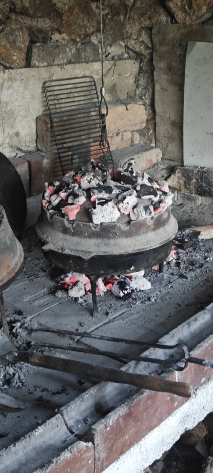 Traditional sač slow-cooking under hot coals